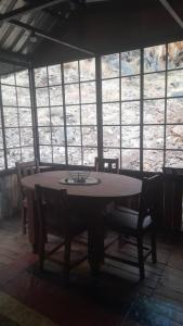 een tafel en stoelen in een kamer met ramen bij Glocke Mountain Camp, Cabin in Outjo