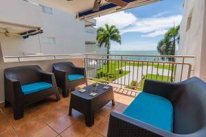 a balcony with chairs and tables and a view of the ocean at Isla Apartment in Ocean Club Rincon in Corcega