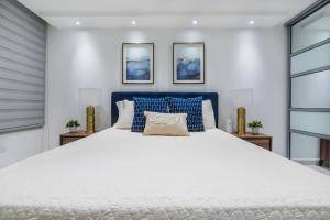 a bedroom with a large white bed with blue accents at Isla Apartment in Ocean Club Rincon in Corcega