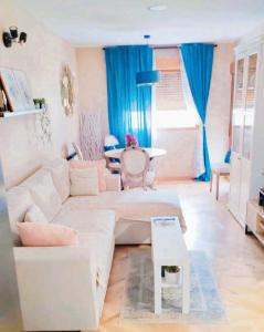 a living room with a white couch and a table at Precioso piso con increíbles vistas en Piedralaves, Tiétar in Piedralaves