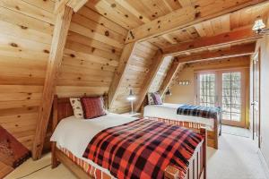 two beds in a log cabin bedroom with wooden walls at Serene Lakes Splendor in Soda Springs