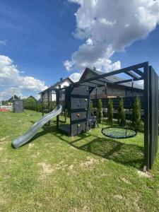 a playground with a slide in the grass at Sister's House Zator in Zator