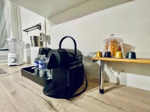 een tafel met een tas op de grond naast een tafel met een lamp bij Grand T2 au RDC hyper centre Navette et Sauna en option in Beauvais