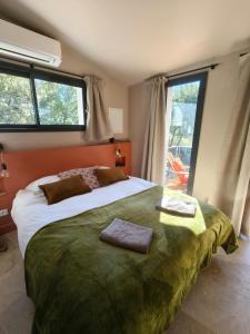 Un dormitorio con una cama grande con dos toallas encima. en La Grange d'Andrea, en Saint-Étienne-de-Fontbellon 8 fotos más