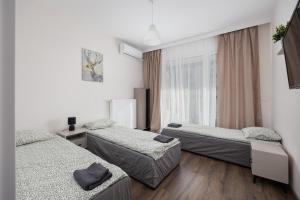 a room with three beds and a window at Pokoje Warszawski Świt in Warsaw