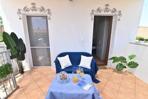 a living room with a blue couch and a table at IzzHome Sea Style Room in Pula