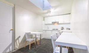 - une cuisine avec des placards blancs, des tables et des chaises blanches dans l'établissement Corazón de Cusco 2, à Cusco