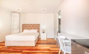 une chambre blanche avec un lit et un bureau dans l'établissement Corazón de Cusco 2, à Cusco