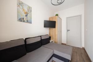 a living room with a couch and a clock on the wall at Pokoje Warszawski Świt in Warsaw