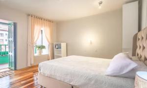 une chambre avec un lit blanc et une fenêtre dans l'établissement Corazón de Cusco 2, à Cusco