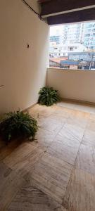an empty room with plants on the floor and a window at Apartamento - Centro Itapuã - 1Q in Vila Velha