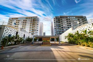 a parking lot in front of two tall buildings at Consulado USA en Merida in Xcumpich
