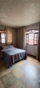 a bedroom with a bed with two windows in it at Apartamento - Centro Itapuã - 1Q in Vila Velha