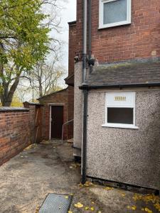 ein Backsteingebäude mit einem Seitenfenster in der Unterkunft Modern 3Bed Doncaster Home with Vintage Charm in Balby + 71 Fotos