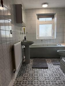 ein Badezimmer mit Waschbecken und Badewanne und Waschbecken in der Unterkunft Modern 3Bed Doncaster Home with Vintage Charm in Balby