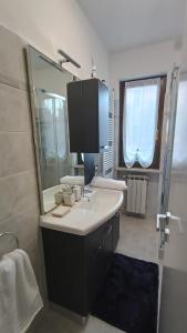 een badkamer met een wastafel en een spiegel en een douche bij Appartamento Polpenazze - Relax in collina con piscina in Polpenazze del Garda