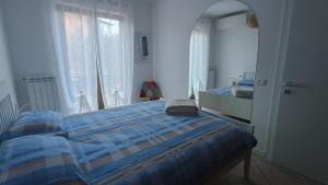 een slaapkamer met een bed en een spiegel bij Appartamento Polpenazze - Relax in collina con piscina in Polpenazze del Garda
