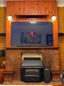 einen Kamin mit einem TV darüber. in der Unterkunft Modern 3Bed Doncaster Home with Vintage Charm in Balby