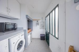 a laundry room with a washing machine and a window at Peaceful Panorama by YOUR KEY MADEIRA in Porto Moniz +15 photos