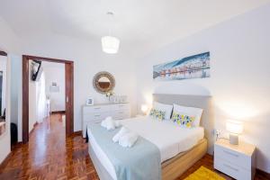a white bedroom with a bed and a dresser at Peaceful Panorama by YOUR KEY MADEIRA in Porto Moniz