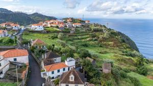 an aerial view of a village on a hill next to the ocean at Peaceful Panorama by YOUR KEY MADEIRA in Porto Moniz