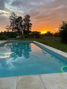 a large swimming pool with a sunset in the background at Las Moras saladillo in Saladillo