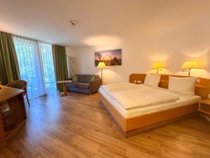 a bedroom with a bed and a living room at Hotel - Restaurant Bastenhaus in Dannenfels +37 photos