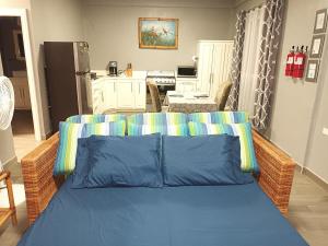 a bedroom with a blue bed with a kitchen at Blue Morpho Suite in Orange Walk +30 photos