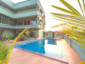a house with a swimming pool in front of a house at Beach Aura By Lavika Stays in Nagaon