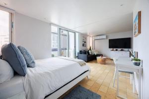 サンファンにあるAMARE Cozy Studio with Generator in Condadoの白いベッドルーム(ベッド1台付)、リビングルーム