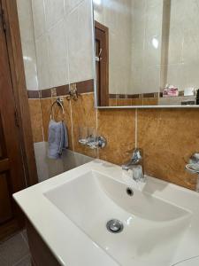 een badkamer met een witte wastafel en een spiegel bij 3 Bedroom Family Apartment in Amman in Amman