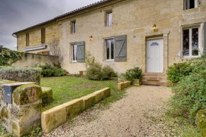 a brick house with a white door and a yard at Gîte familiale 3 chambres, au coeur des vignes in Saint-Christophe-des-Bardes