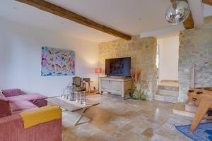 a living room with a couch and a tv at Gîte familiale 3 chambres, au coeur des vignes in Saint-Christophe-des-Bardes