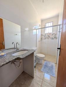 a bathroom with a sink and a toilet at Sítio Vista Azul - Lazer e descanso na natureza in Mateus Leme