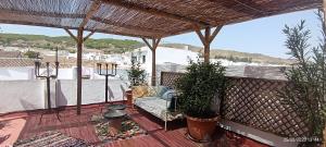 a patio with a couch on a deck with a roof at Oasis de Bornos Maison Entière in Bornos