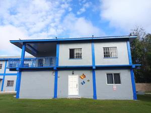 a blue and white building with a balcony at Blue Morpho Suite in Orange Walk