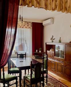 Un comedor con mesa y sillas y una ventana. en Small Hill Guesthouse, en Podgorica