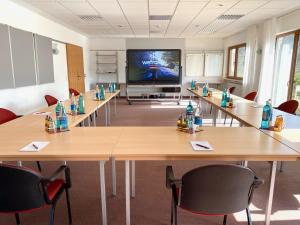 a conference room with tables and a flat screen tv at Hotel - Restaurant Bastenhaus in Dannenfels +36 photos
