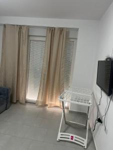 a room with a window with a shelf and a television at Sea view in Shëngjin