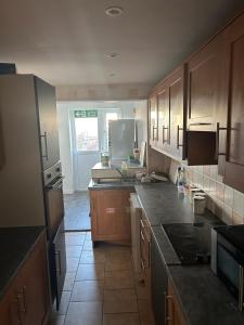 Una cocina con gabinetes de madera y encimera. en The Sawyers Court Home, en Chatham