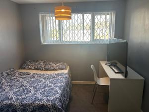 Un dormitorio con una cama y un escritorio y una ventana. en The Sawyers Court Home, en Chatham