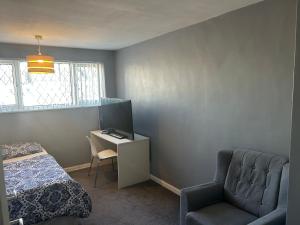 Un dormitorio con una cama, una silla y un escritorio. en The Sawyers Court Home, en Chatham