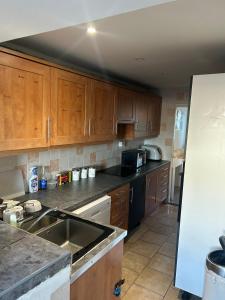 Una cocina con gabinetes de madera, un fregadero y un refrigerador. en The Sawyers Court Home, en Chatham 10 fotos más