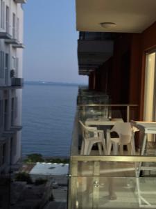 a balcony with a table and chairs and the water at Sea view in Shëngjin