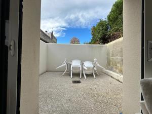 een tafel en 2 stoelen op een patio bij Chez Camille & Emma - Climatisé in Rochefort