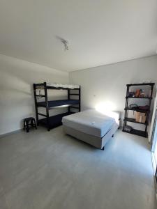 een slaapkamer met een bed en 2 stapelbedden bij Chalé do João in Ubatuba