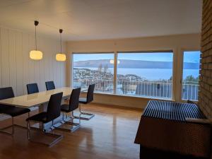 een vergaderzaal met een tafel en stoelen en een groot raam bij Aurora Seaview Escape E33 in Slåttvikstrand