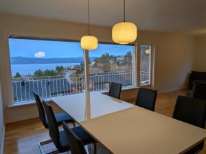 een vergaderzaal met een tafel en stoelen en een groot raam bij Aurora Seaview Escape E33 in Slåttvikstrand