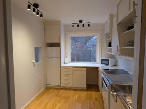 een keuken met witte kasten en een raam erin bij Aurora Seaview Escape E33 in Slåttvikstrand