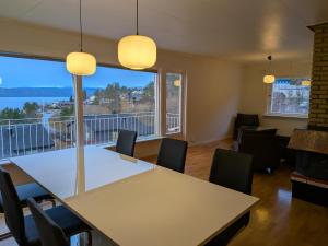 een eetkamer met een tafel en stoelen en een groot raam bij Aurora Seaview Escape E33 in Slåttvikstrand +5 foto's